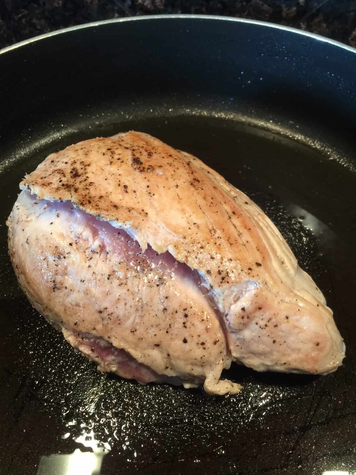 Picture of browned pork roast in a skillet.