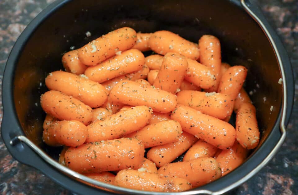 Baby Carrots and spices in a pot tossed and ready for cooking.