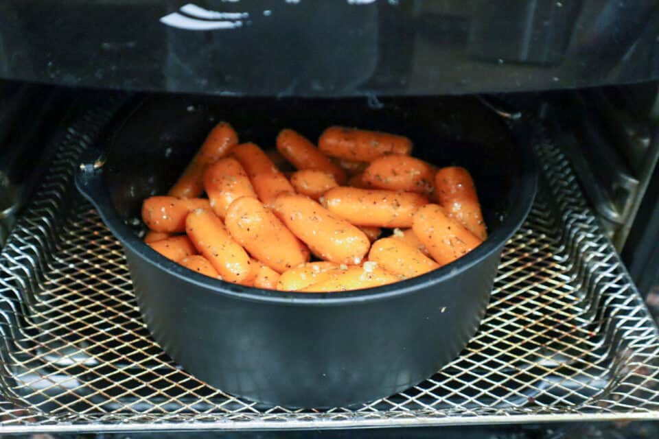 Baby Carrots in the pot in the air fryer in a rack.