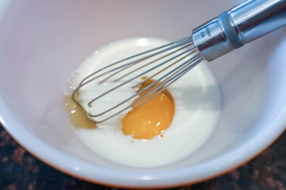 Picture of egg, milk and whisk in a small bowl