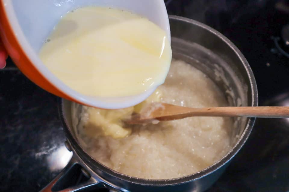 Picture of Milk and egg mixture being tempered into rice mixture on stovetop for Classic Rice Pudding