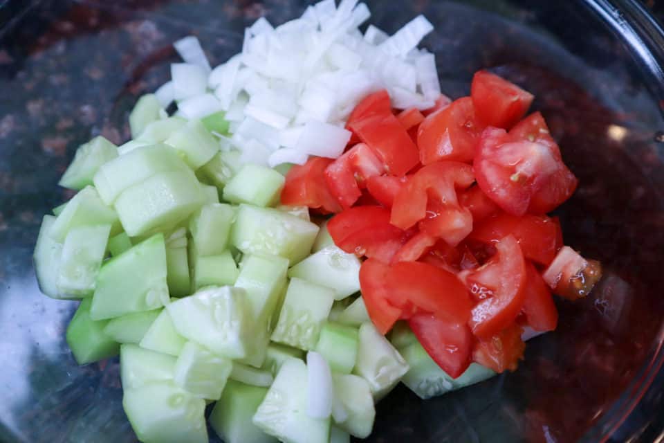 Cucumber, tomato and onion cut into bite sized pieces.