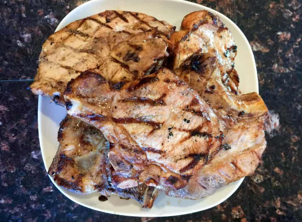 Finished picture of grilled pork chops on a plate after being marinated in Pantry Pork Chop Marinade.