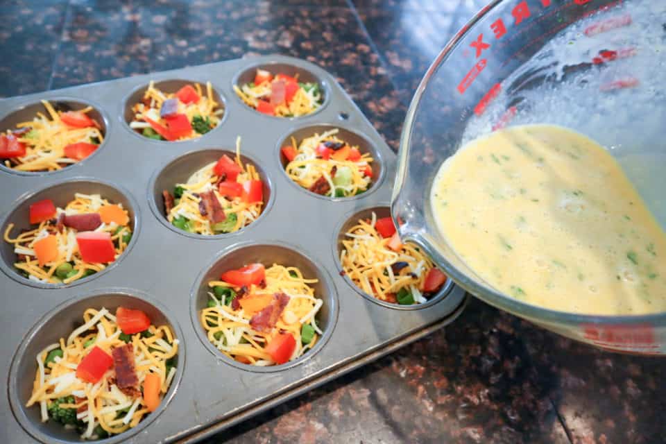 Egg mixture being added to muffin tins.