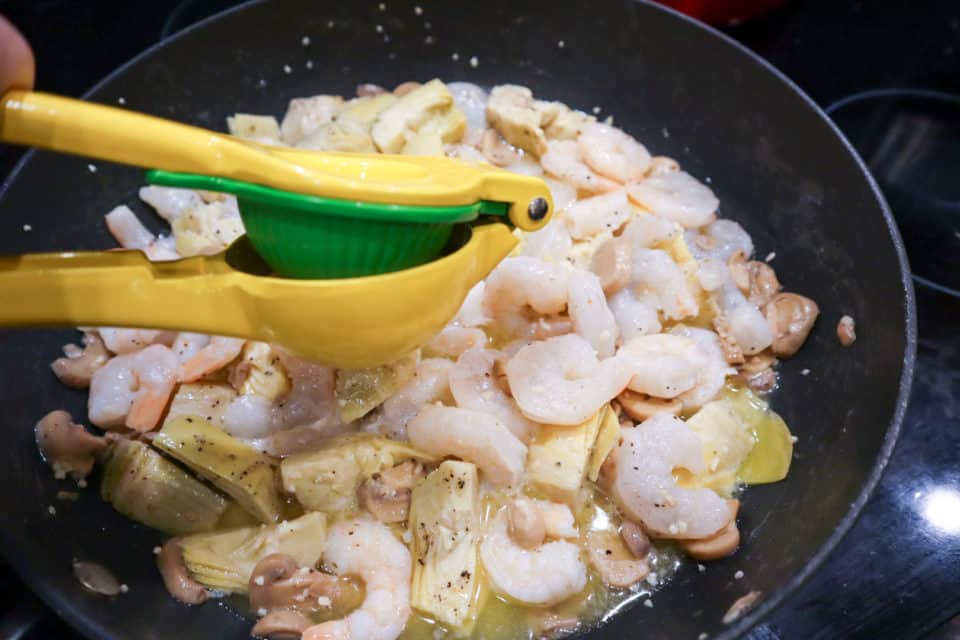 Lemon being added to the skillet for Weeknight Shrimp Portofino.