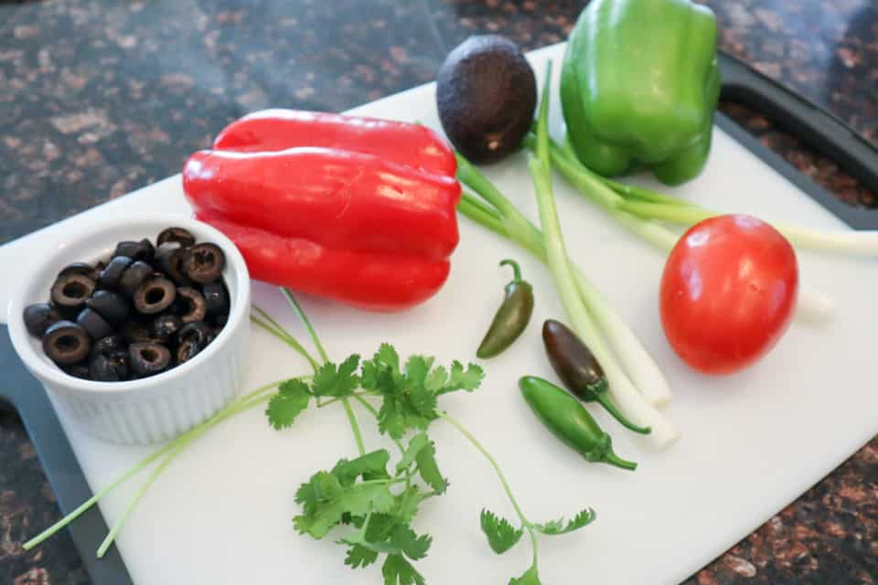 Picture of garnish ingredients on a cutting board for Oven Baked Taco Casserole.