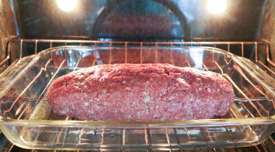 Uncooked Simple Weeknight Meatloaf in a glass baking dish in the oven.