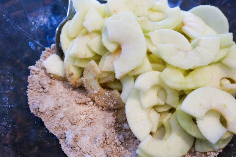 Apple slices atop dry ingredients for Caramel Apple Pie.