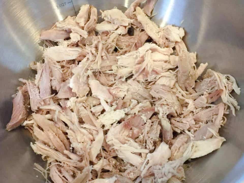 Leftover turkey cut into bite sized pieces in a bowl.
