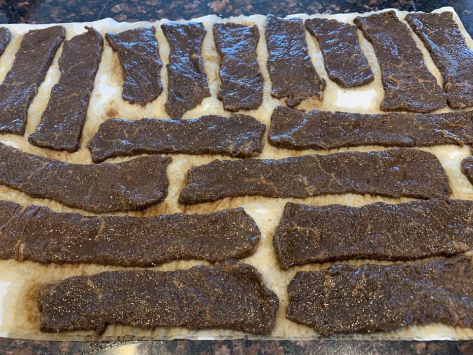 Marinated Worcestershire Beef Jerky strips on paper towel.