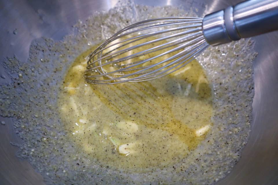 Picture of mixed marinade for Oven Roasted Cauliflower with a whisk.