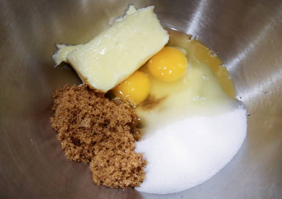 Butter, sugars and eggs in a bowl.
