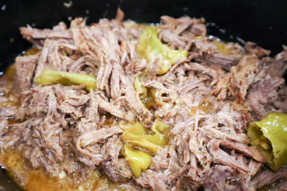 Shredded Mississippi Pot Roast and pepperoncinis in a slow cooker