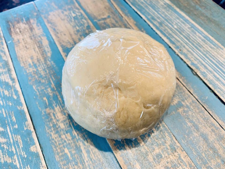 Fresh Homemade Pasta dough ball wrapped in plastic wrap to rest.