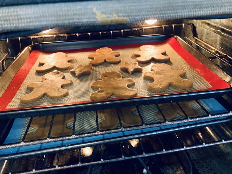 Small Batch Gingerbread Friends in the oven, ready for baking on silicone lined baking sheets.