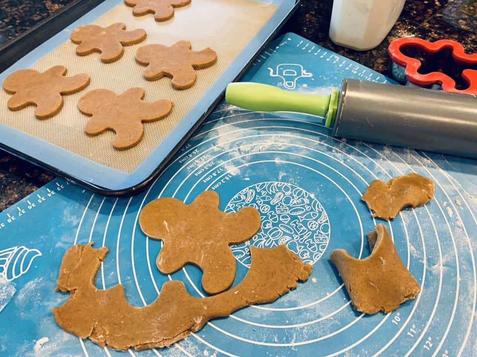 Rolling out the dough and cutting out the Small Batch Gingerbread Friends in different shapes.
