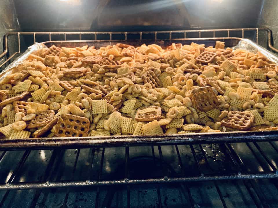 Savory Chex Mix in the oven on a baking sheet.