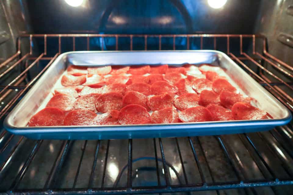 Image of pepperoni slices on a baking sheet in the oven