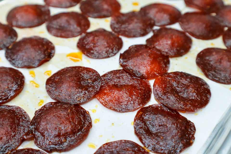 Image of browned pepperoni chips on a baking sheet after baking