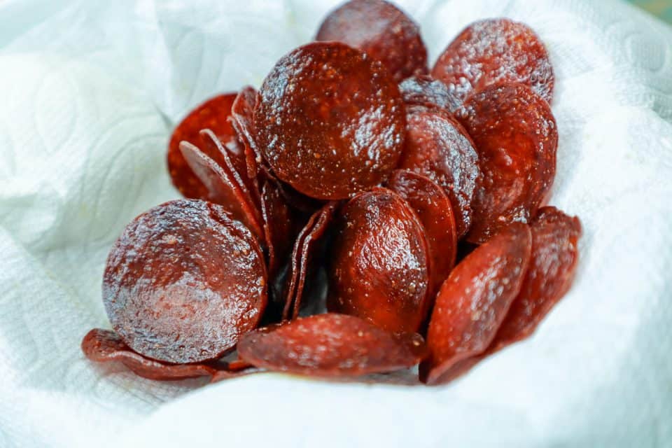 Image of browned pepperoni chips on a paper towel after baking