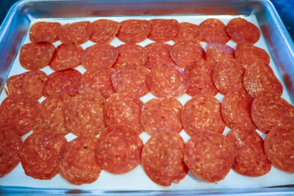 Image of pepperoni slices on parchment paper on a baking sheet