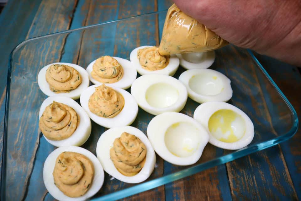 Picture of the filling being piped into the boiled egg white halves for Spicy Deviled Eggs