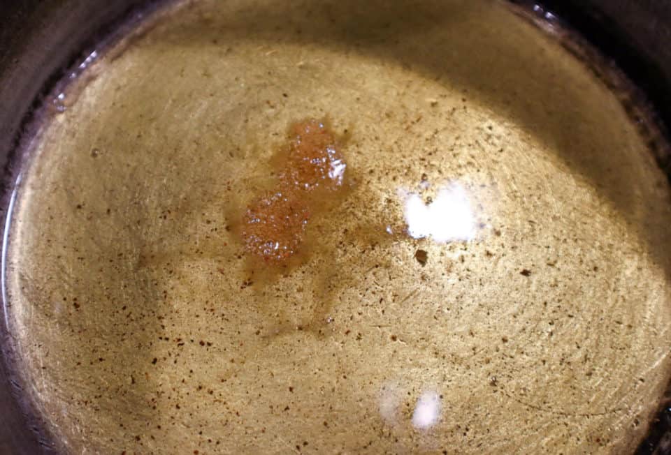 Picture of flour sprinkled in oil in saucepan to check for temperature for Homemade Red Enchilada Sauce.