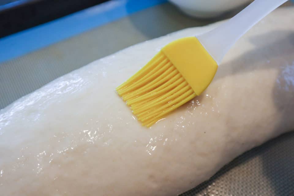 Picture of egg wash being applied to dough with a pastry brush for Everyday French Bread