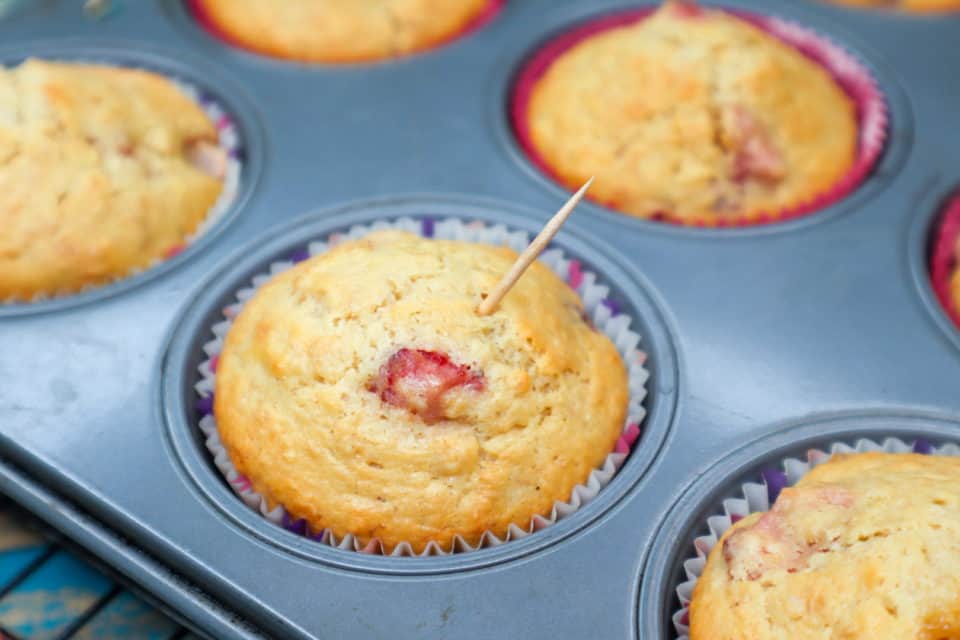Picture of baked Strawberry Banana Oat Bran Muffins with toothpick in one