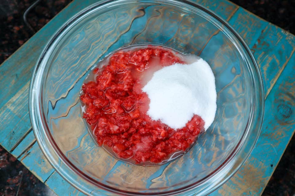 Picture of processed berries, lemon juice, sugar and salt in a bowl prior to mixing for Simple Microwave Strawberry Jam.
