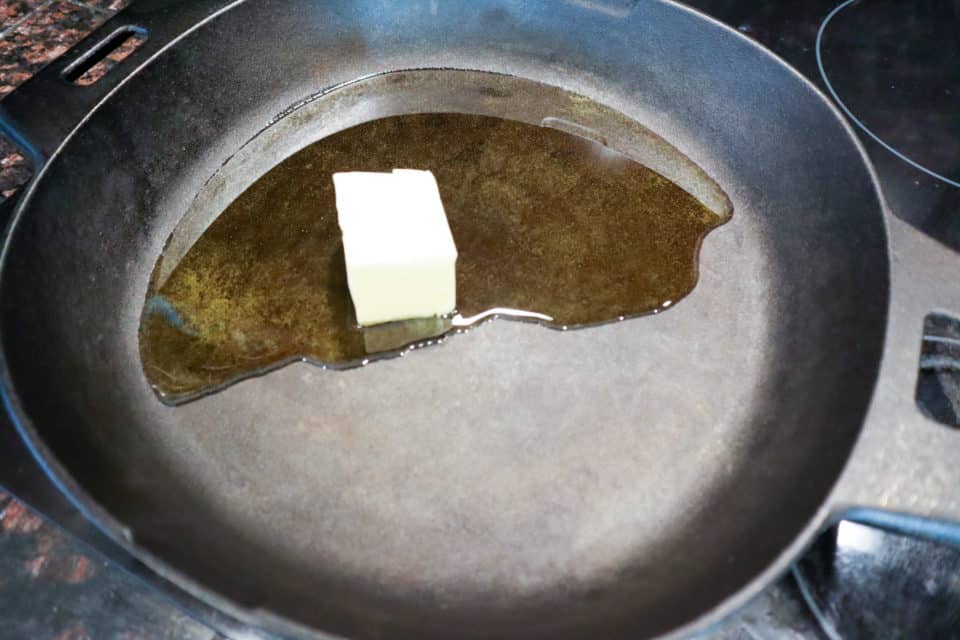 Oil and butter in a cast iron pan before frying the pork chops for Pork Scallopini with Lemon Caper Sauce.
