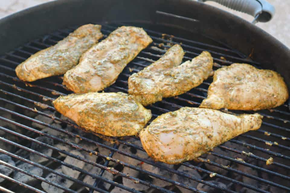 Picture of marinated chicken breasts on the charcoal grill.