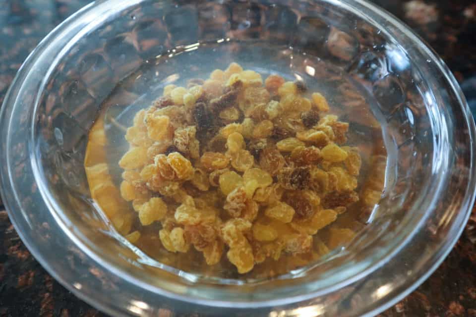 Picture of raisins soaking in water in a bowl. 
