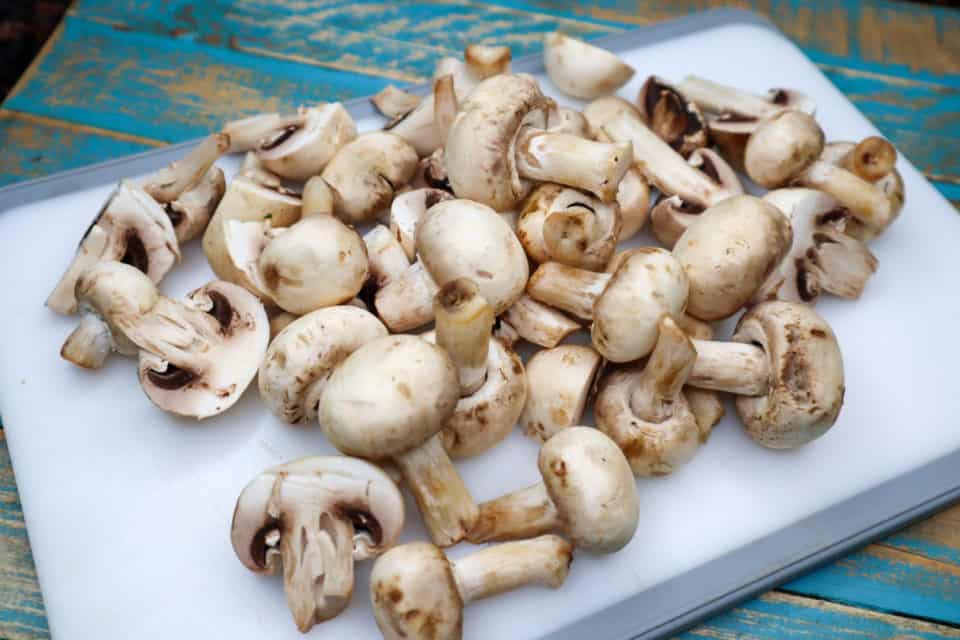 Picture of washed mushrooms on a cutting board for Easy Italian Pickled Mushrooms.