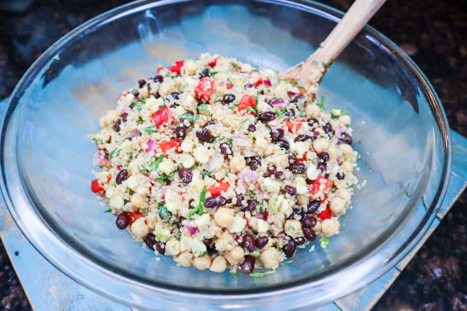 Picture of finished Southwestern Quinoa Salad in a bowl with a wooden spoon.