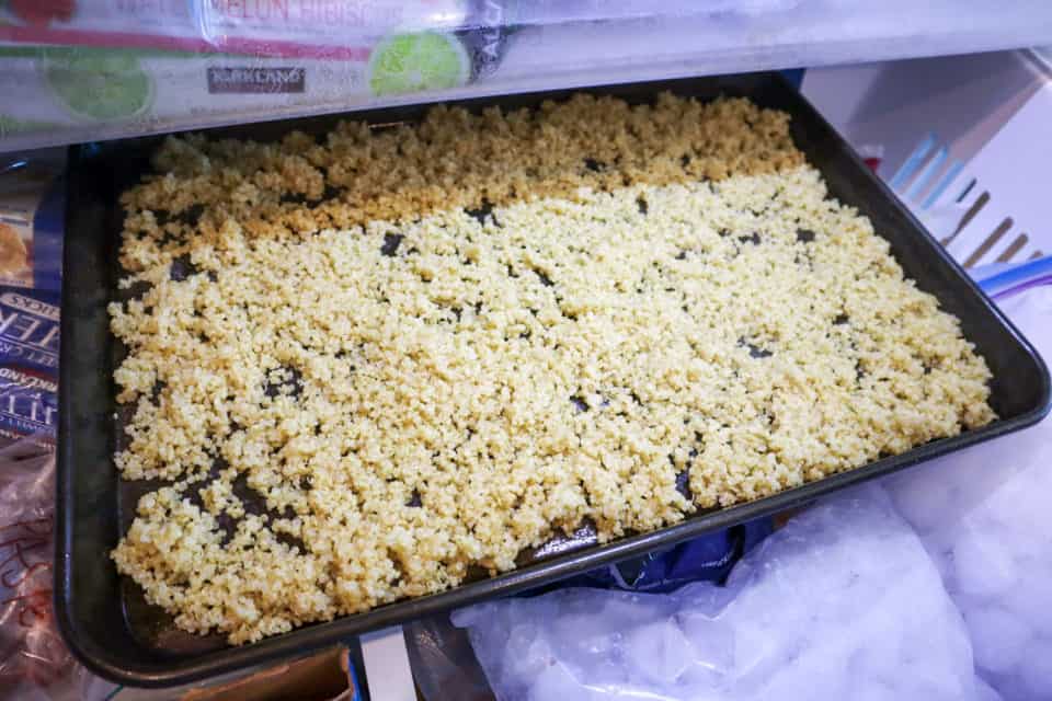 Picture of finished Easy Instant Pot Quinoa on a baking sheet being placed in the freezer.
