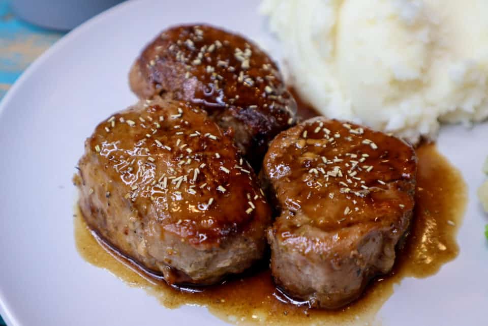 Finished Pork Medallions with Balsamic Honey Sauce on a plate with mashed potatoes.