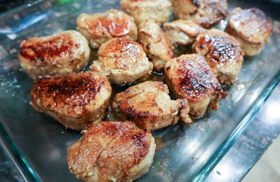 Browned pork medallions in a 9x13 baking dish.