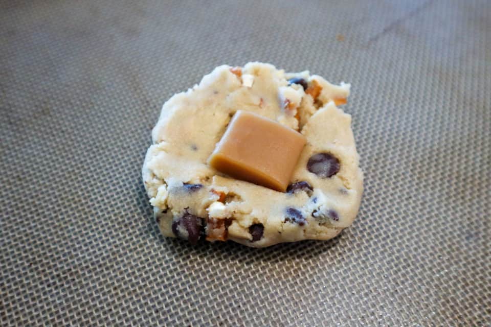 Cookie dough with a piece of caramel embedded in the center.