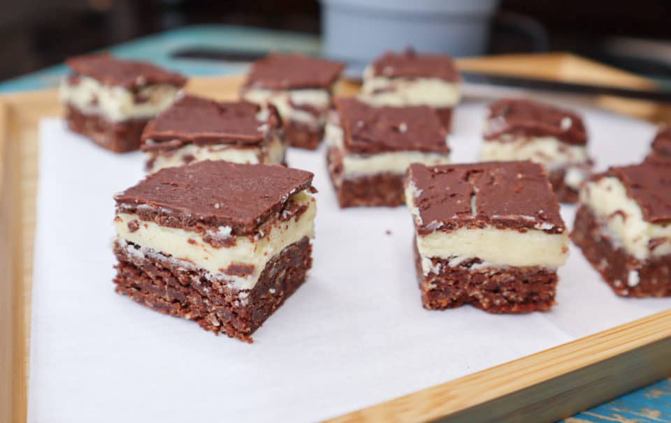 Finished Nanaimo Bars on a platter, cut into squares.