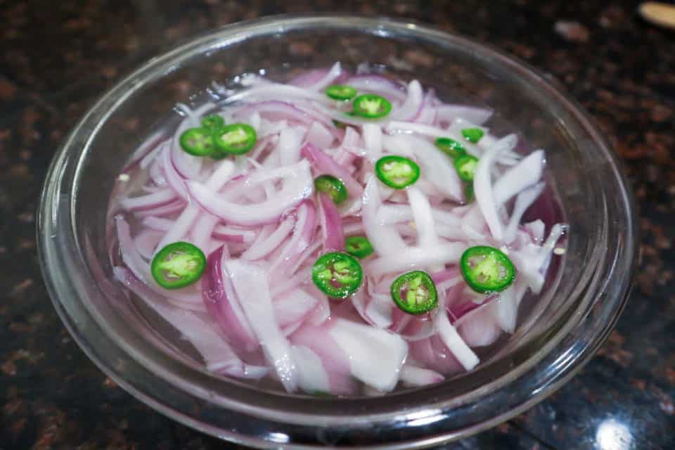 Sliced onions and jalapenos in hot water.