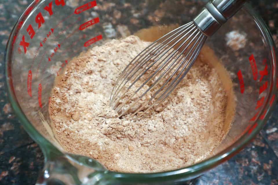 Dry ingredients in a large measuring cup with a whisk.