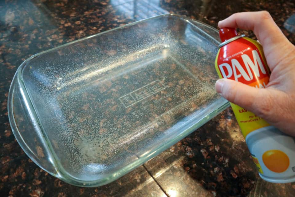 Coating a 9x13 cooking dish with non stick spray.