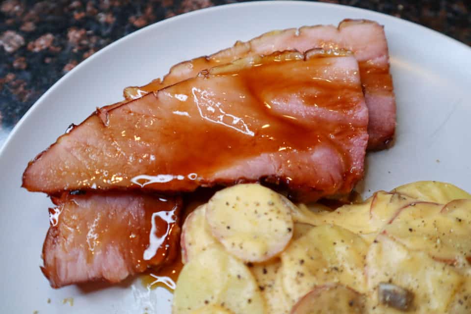 Easy Brown Sugar Glaze Spooned over ham slices on a plate