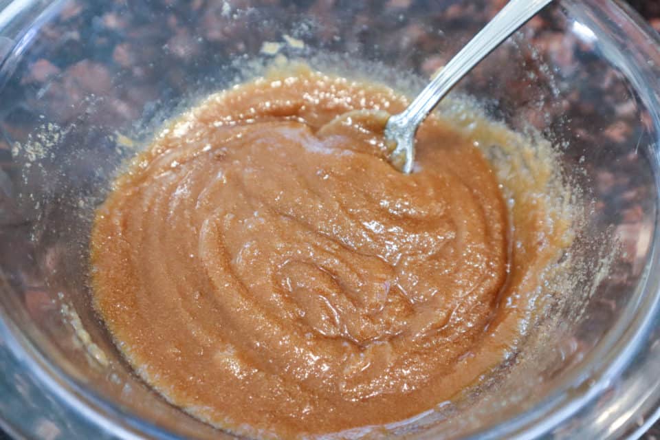 Easy Brown Sugar Glaze ready to use in a bowl with a spoon.