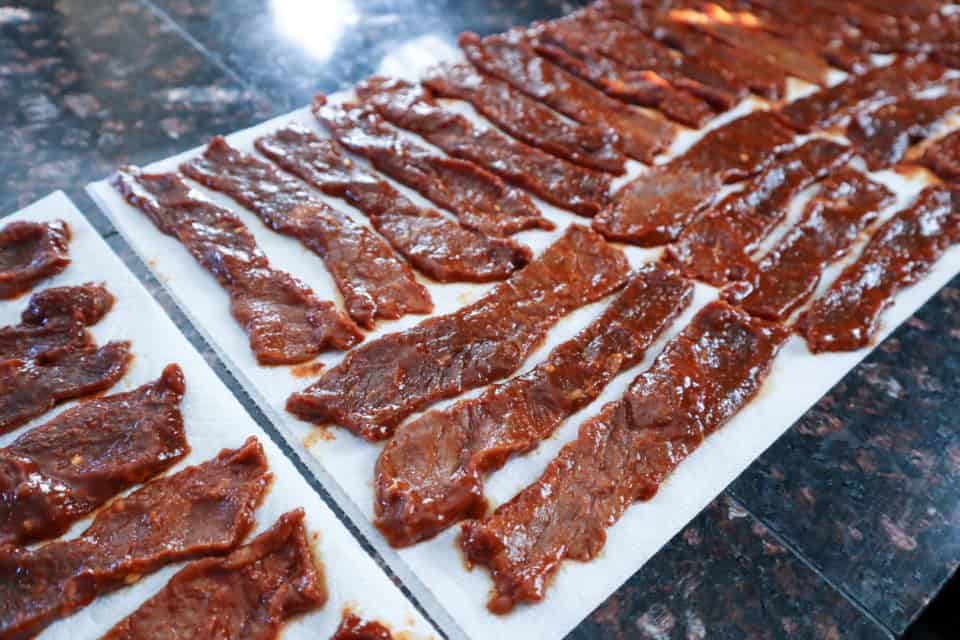 Korean BBQ Beef Jerky strips laid out on paper towels.