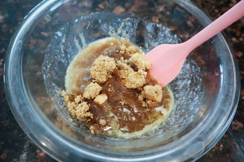 Brown sugar being stirred into melted butter.