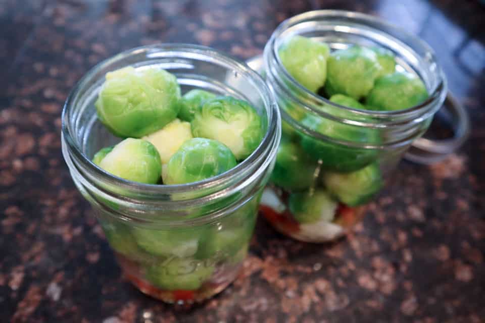 Brussels sprouts packed into the pint jars.