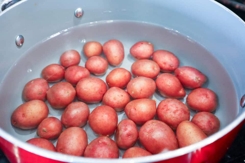 Baby potatoes in a pot of water.