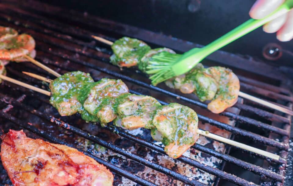 Shrimp being brushed with Fresh Lime Chimichurri Sauce while grilling.